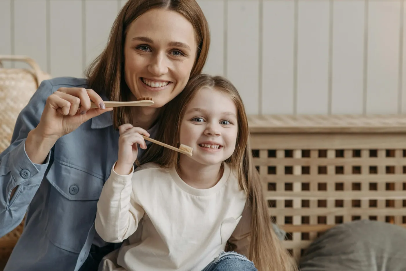 Mother and daughter brushing their teeth together